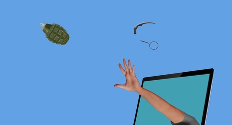 Hand throwing grenade out of laptop screen