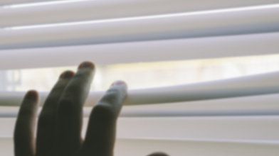 Fingers pulling down blind